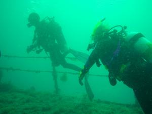 [Amanda on the ship's deck. The diver behind is the dive instuctor / guide, but he was so thin that in this photo he looks like some kind of ghoul]